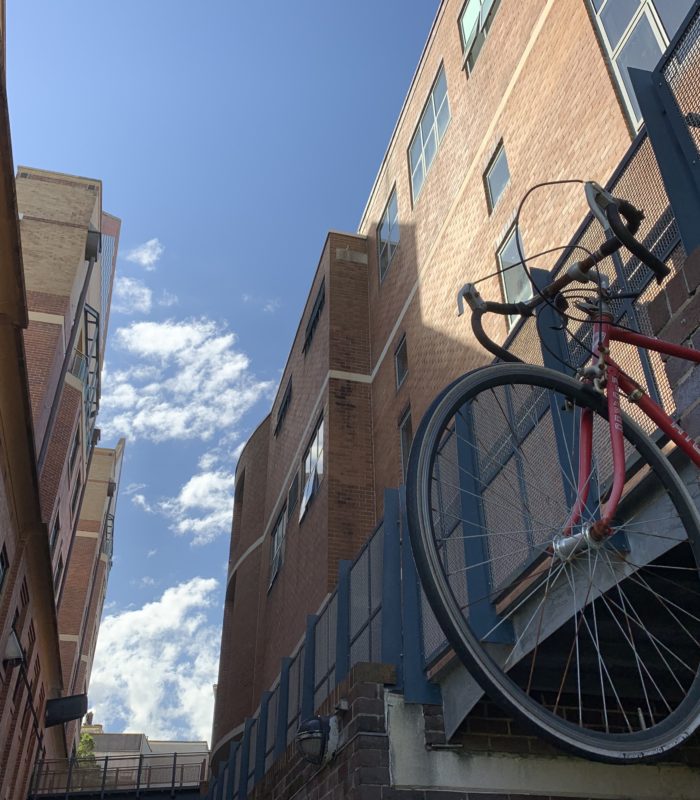 There is a half of a bike on the wall along the lane beside the manning bar.