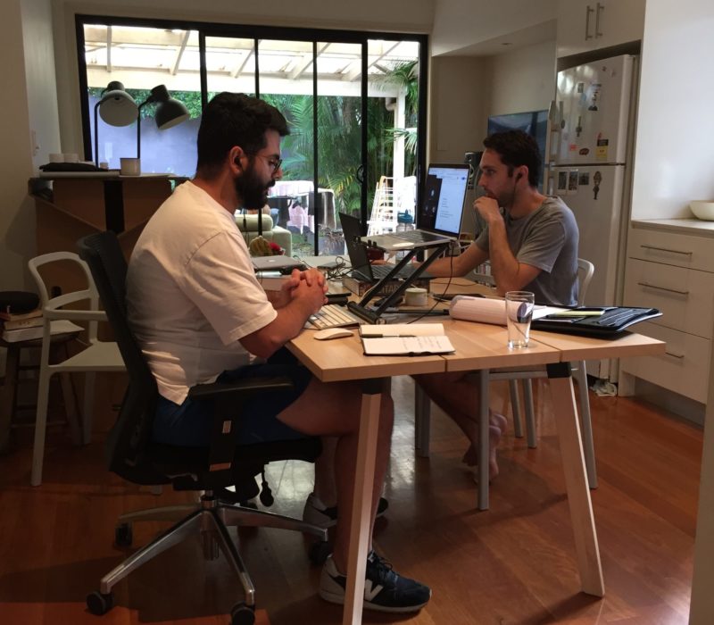 Two housemates sitting by dining table working